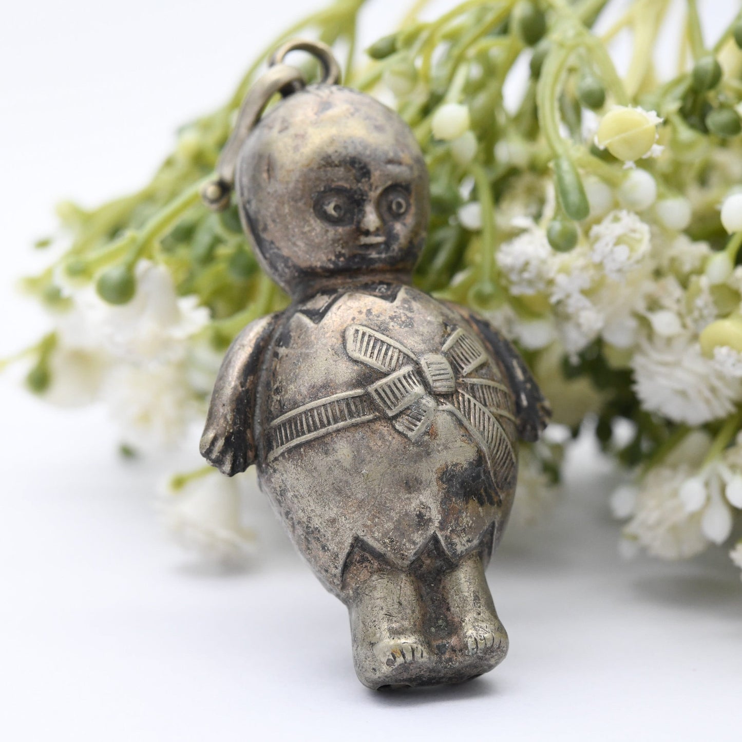 Antique Victorian EPNS Baby Rattle in the Form of a Baby wearing a Cracked Egg and a Bow